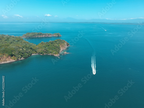 Aerial drone picture of a High speed boat at Chiriqui Panama Pacific Ocean, Parida Island with green trees and blue sea