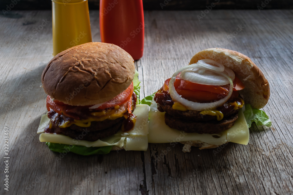 dos hamburguesas hechas en casa con pan, cebolla, tomate, carne, queso