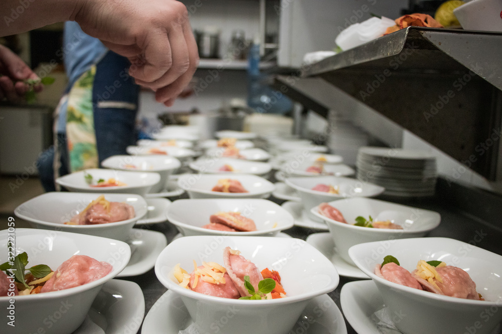Chef spicing up plates of pink ravioli