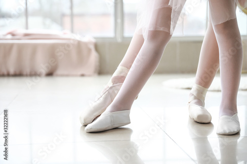 Little ballerina training with coach in dance studio