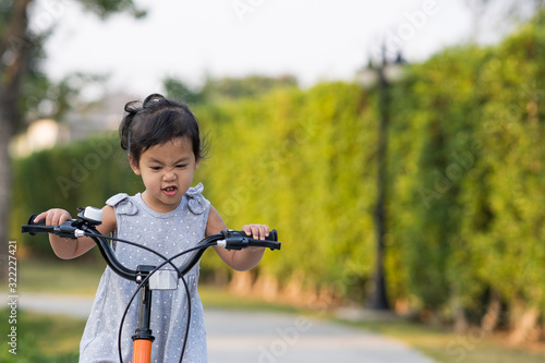Cute Little Girl Riding Her Orange Bike in the Park 