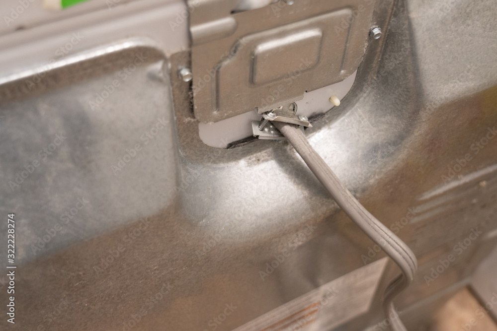 Ταπετσαρία Electrical cord clamped to the back of a dirty residential dryer.