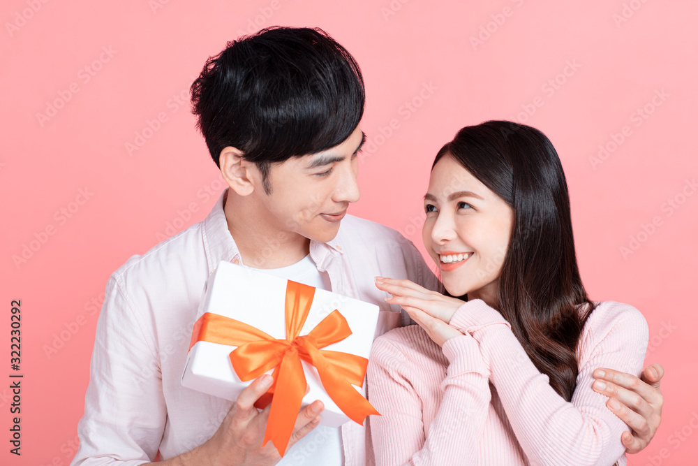 Happy young couple celebrating valentines day and holding gift box Happy young couple celebrating valentines day and holding gift box