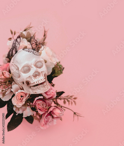 Fototapeta Naklejka Na Ścianę i Meble -  skull with flowers on pink background. surreal creative concept. artistic magic image. close up. copy space