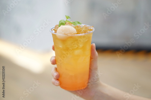 A plastic glass of Iced lychee rose cold brew tea on blurred background  Perfect drink for summer time.