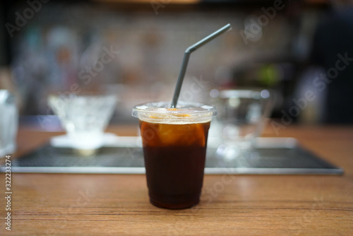 Iced coffee with orange - A plastic glass of espresso shot mixed with orange juice and craft soda on blurred background, Perfect drink for summer time.