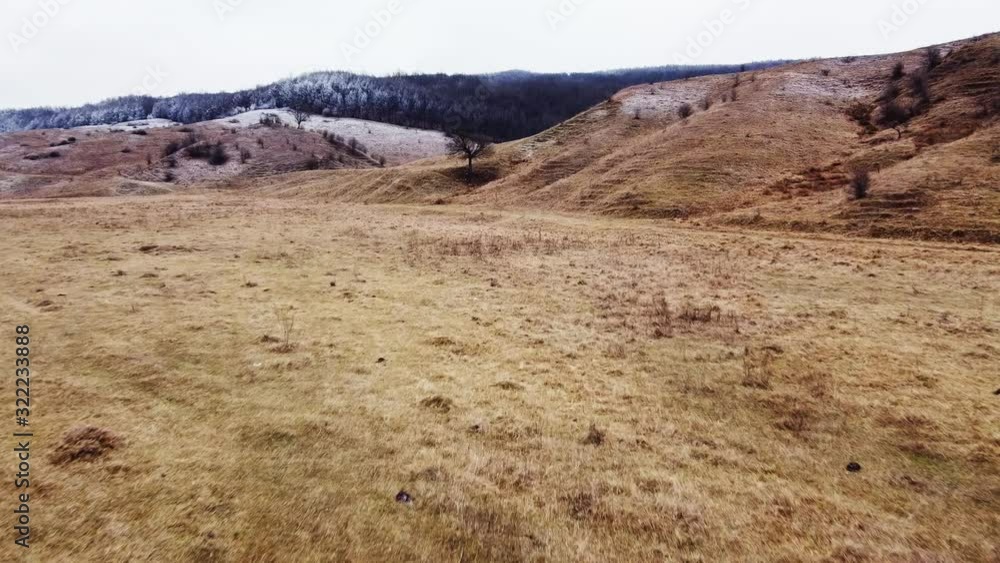 Aerial drone shot of a country region with hiils and dead vegetation in autumn season, daytime Aerial drone shot of a country region with hiils and dead vegetation in autumn season, daytime