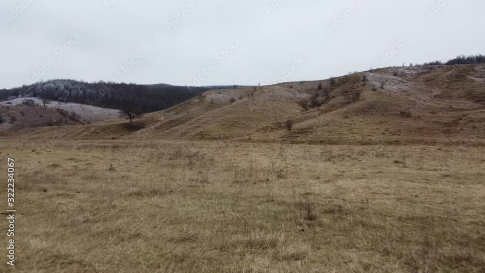 Aerial drone shot of a country region with hiils and dead vegetation in autumn season, daytime Aerial drone shot of a country region with hiils and dead vegetation in autumn season, daytime