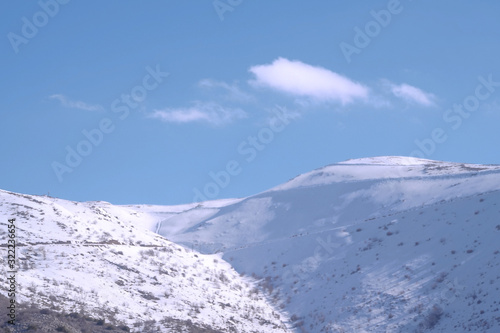 A beautyfool panoramic view of snowy mountain. Dramatic clouds. Trees in the Shed. blue sky. Mt hermon the higher mountain in Israel. © Avishay