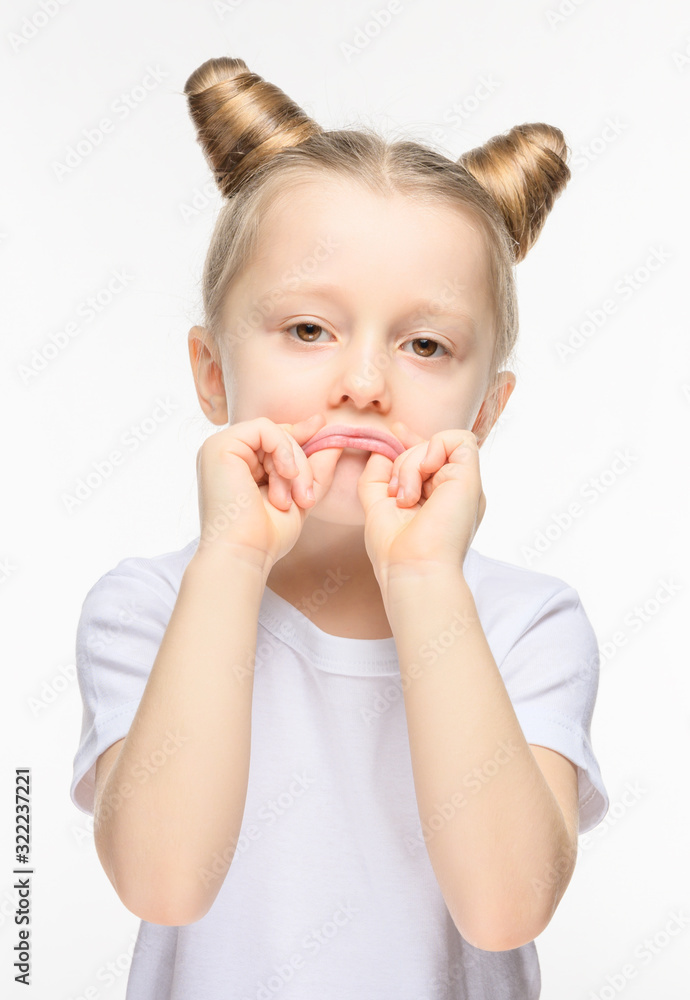 Little girl made a sad grimace on a white background. The concept of manifestation of discontent or whim. Little girl made a sad grimace on a white background. The concept of manifestation of discontent or whim.