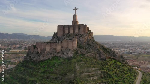 Aerial footage circling the Sacred heart statue of Jesus on top of Monteagudo castle near Murcia Spain during sunset photo