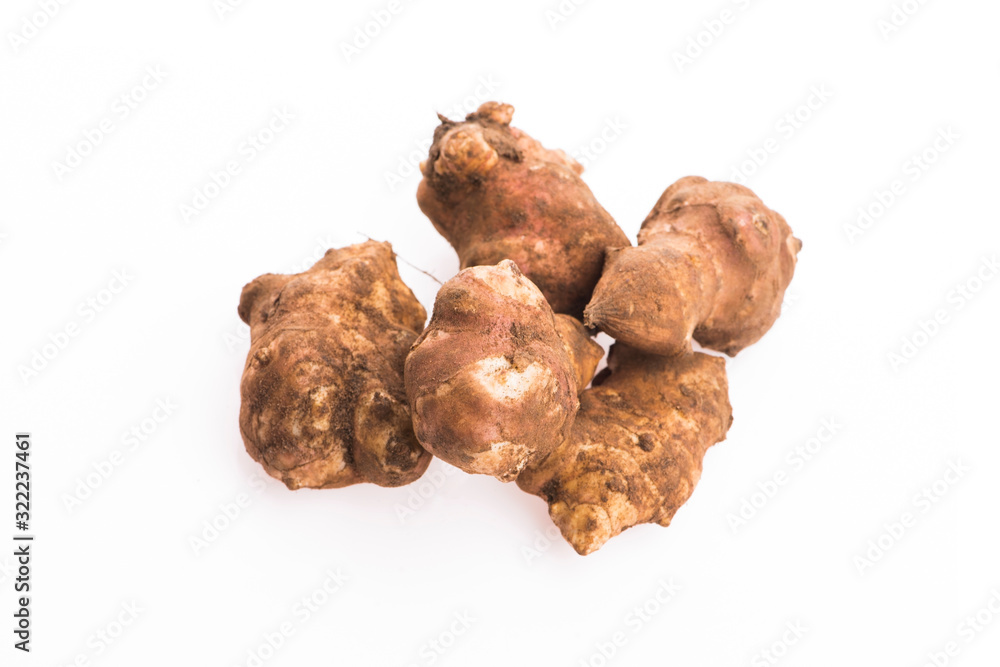 Raw Whole ans sliced Jerusalem artichokes on a white background