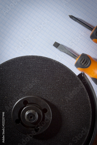 Angle grinder and screwdrivers on notebook