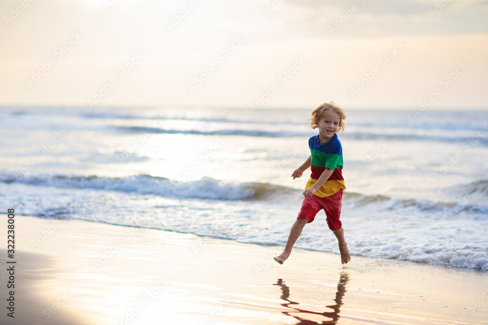Child playing on ocean beach. Kid at sunset sea. Child playing on ocean beach. Kid at sunset sea.