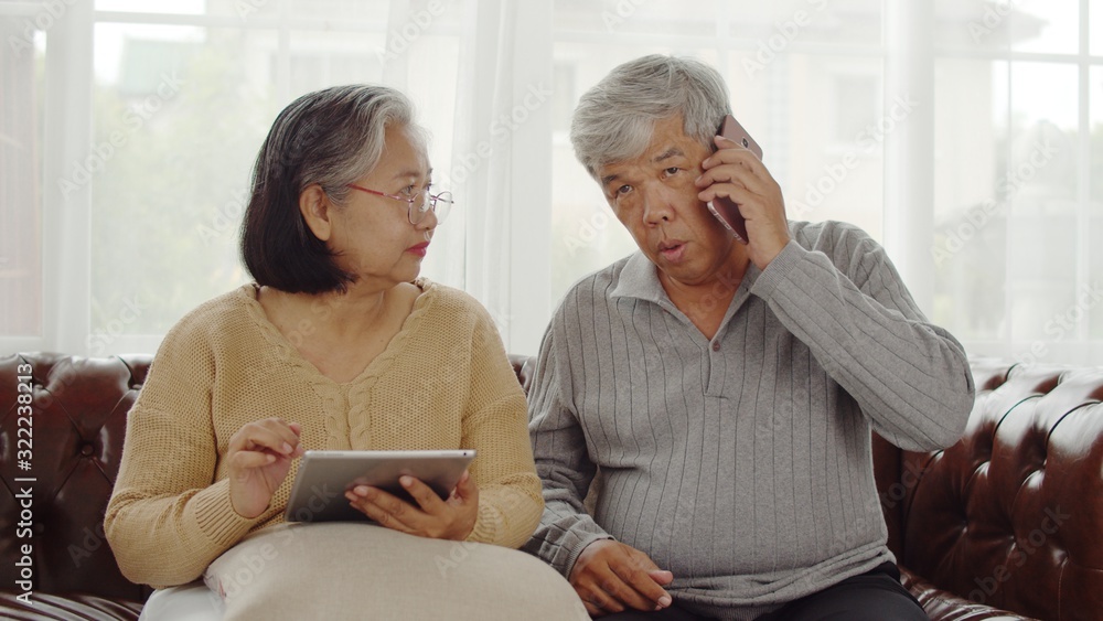 Joyful Senior couple using technology device at home Joyful Senior couple using technology device at home