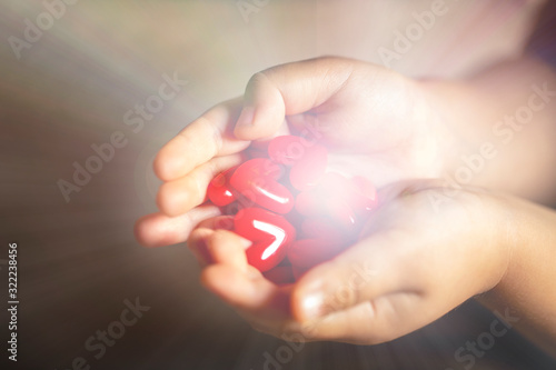 Wallpaper Mural 光を放つ沢山の赤いハートのモチーフを持つ子供の手 Torontodigital.ca