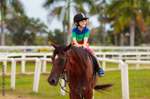 Kids ride horse. Child on pony. Horseback riding. © famveldman