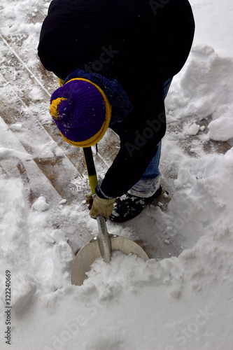 Close up view of an unidentifiable person shoveling deep snow