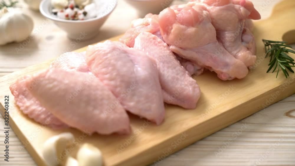 fresh raw chicken wings on wooden board with ingredients fresh raw chicken wings on wooden board with ingredients
