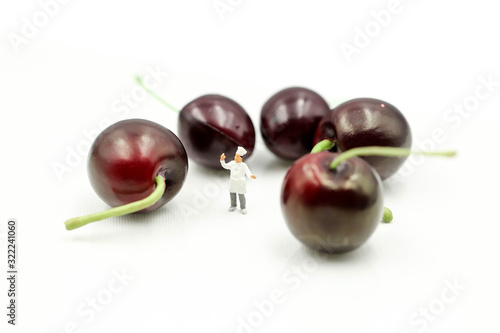 Miniature people : chef with cherrys,cherry month concept.