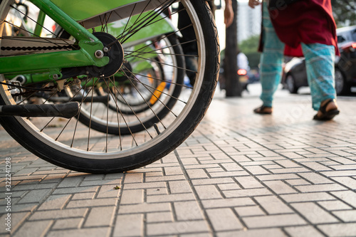 Bicycle wheels on footpath with pedestrian walking