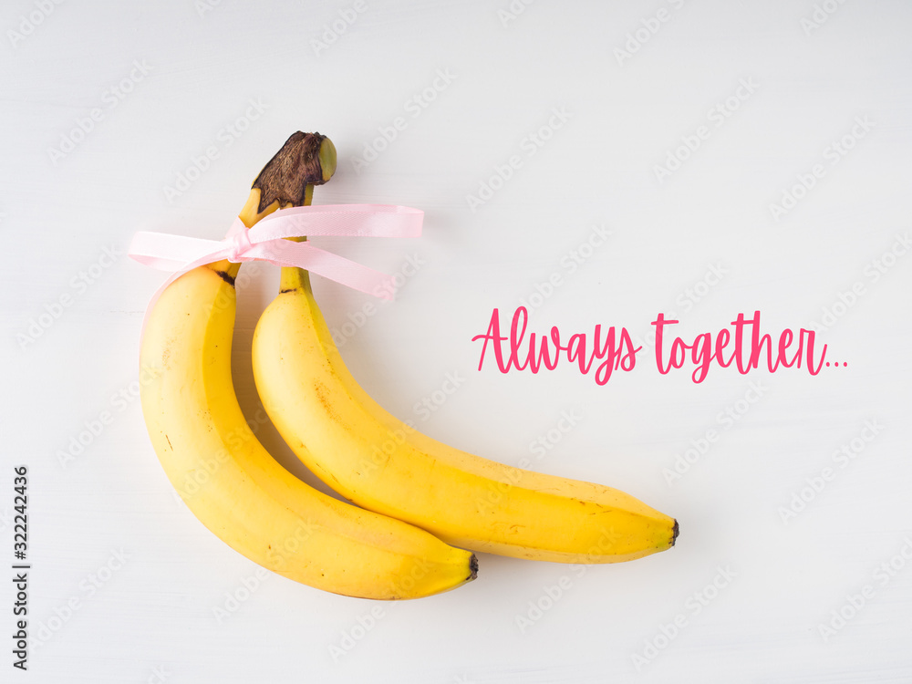 Fotografie Two bananas with pink ribbon