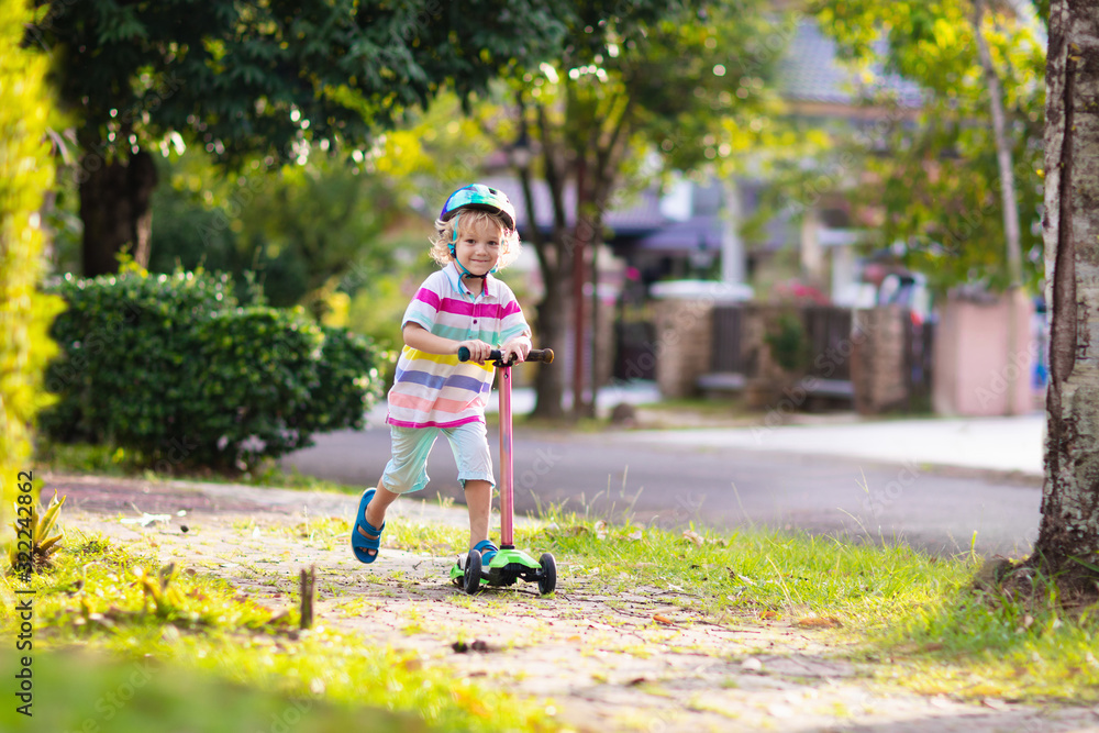 Little boy riding scooter. Kids ride kick board. Little boy riding scooter. Kids ride kick board.