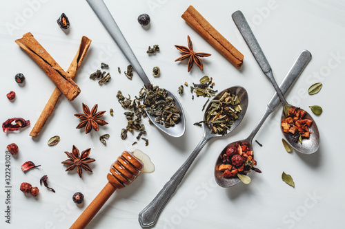 Different herbal tea with honey and spices on white background.