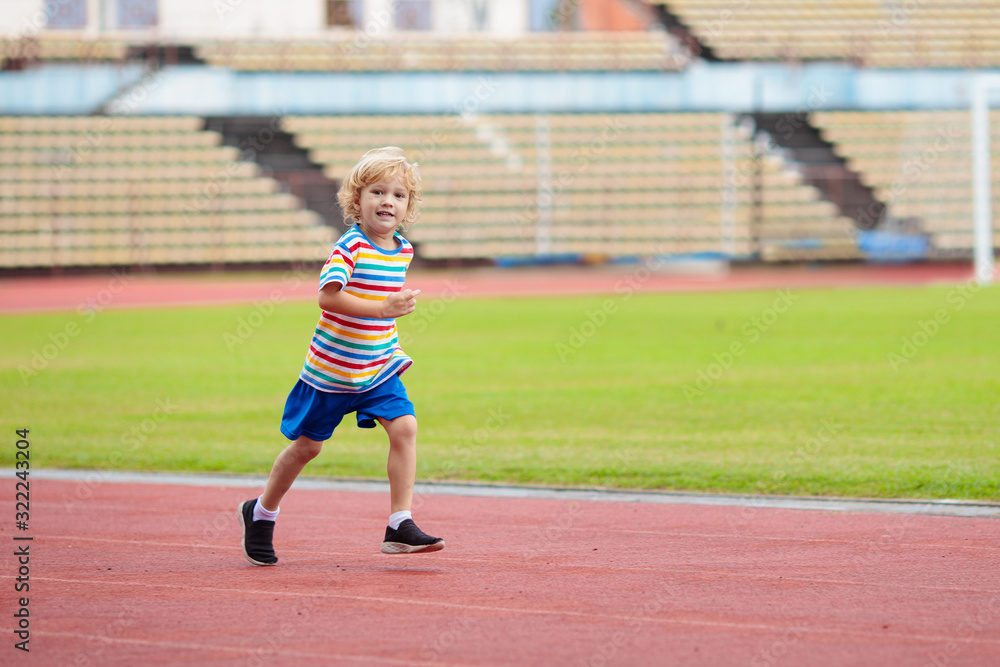 Fototapeta premium Child running in stadium. Kids run. Healthy sport.