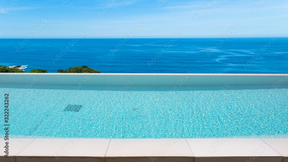 Swimming pool overlooking view andaman sea and clear sky background,summer holiday background concept.