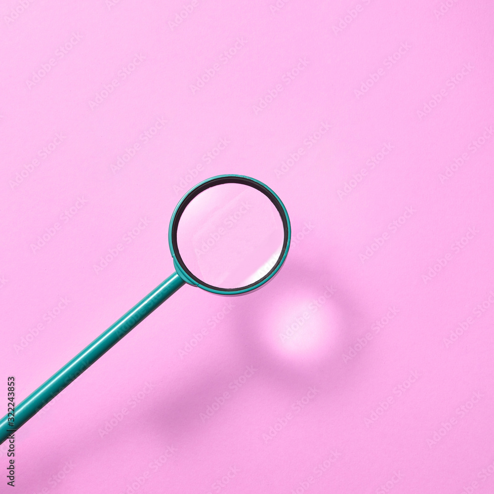 Magnifying glass above pink background with shadows. Magnifying glass above pink background with shadows.