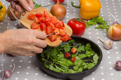 Hands put tomatoes on cutting board photo