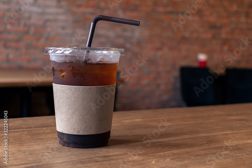 Close up of take away plastic cup of iced black coffee
