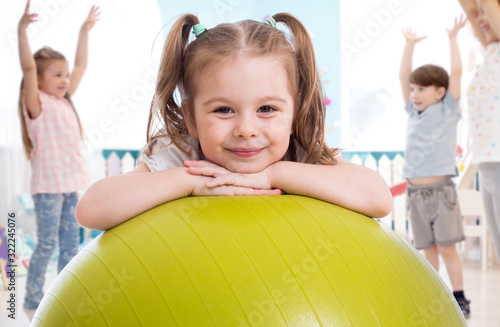 Sporty kid with children group having fun in gym photo