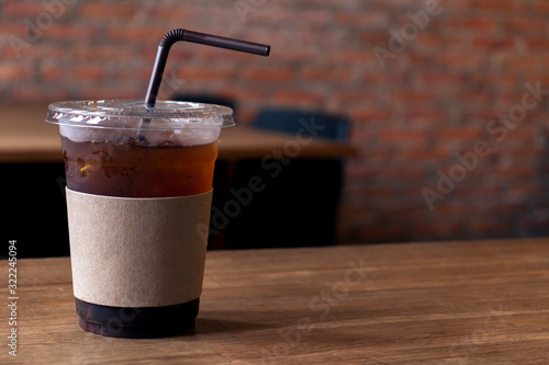 Close up of take away plastic cup of iced black coffee