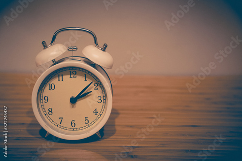 Alarm clock on the wood table beside the bed