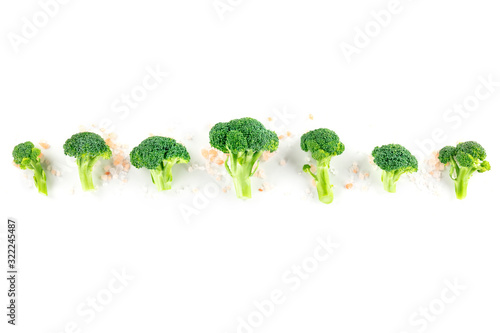 Broccoli florets, shot from the top on a white background with natural salt and copy space
