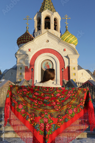 Russian tourist girl in vintage Pavlovo Posad shawl, look. Orthodox Saint Igor Chernigovsky's church in Novo-Peredelkino, Moscow city, Russia. Russian traditional national folk, retro style in fashion photo