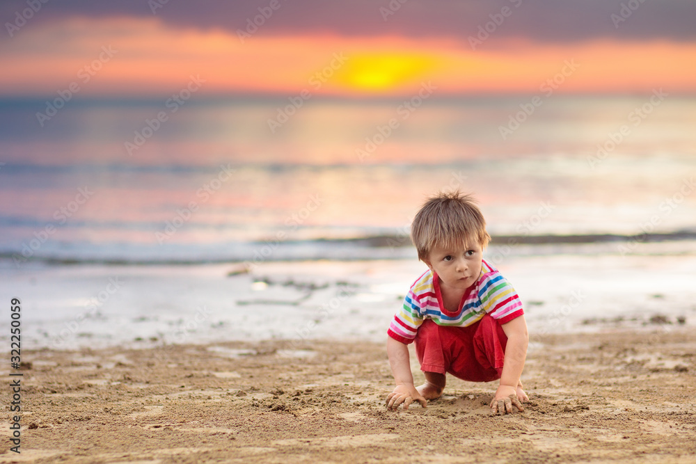 Child playing on ocean beach. Kid at sunset sea. Child playing on ocean beach. Kid at sunset sea.