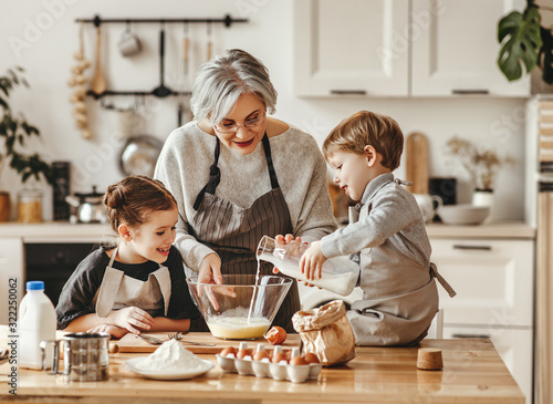 Photo happy family grandmother and grandchildren cook in the kitchen, knead dough, bake cookies