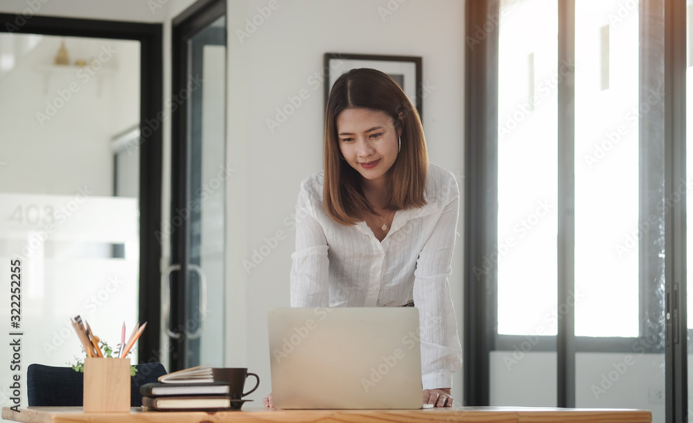 Concept business woman working and people happy businesswoman or creative female office worker with computers writing to notebook with documents and laptop. Concept business woman working and people happy businesswoman or creative female office worker with computers writing to notebook with documents and laptop.