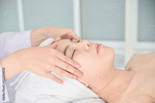 Therapist doing Tui na massage at her patient face ,Chinese alternative medicine.
