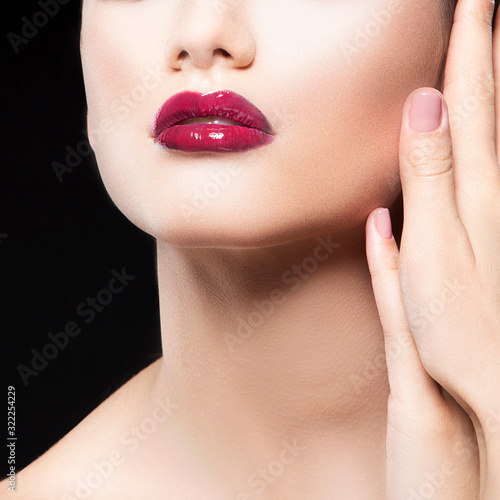 Bright lips and hand near shoulder of young beauty woman