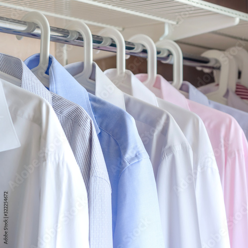 multi-colored ironed men's shirts hang on a hanger, selective focus