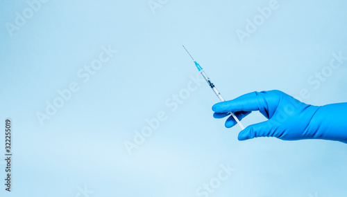 Syringe in the hands in medical gloves. Medicine and vaccination. Banner. Copy space
