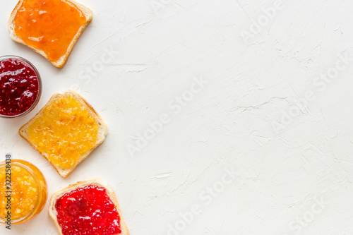 Toast with colorful fruit jam frame on white background frame copy space photo