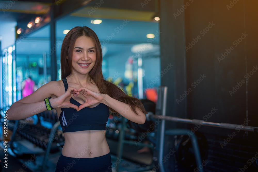 Cute Asian girl is enamored at the gym and she is happy after her workout.