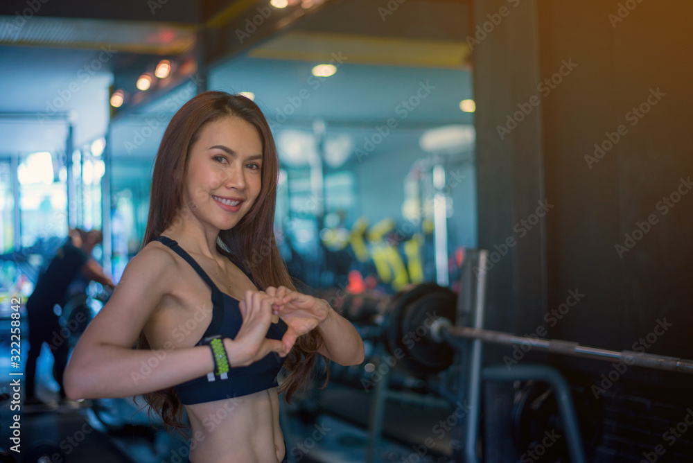 Cute Asian girl is enamored at the gym and she is happy after her workout. Cute Asian girl is enamored at the gym and she is happy after her workout.