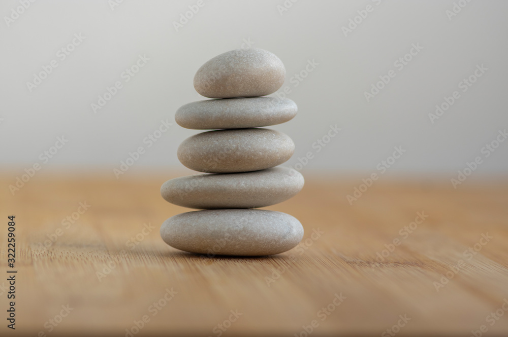 Stone cairn on wooden background, five stones tower, simple poise stones, simplicity harmony and balance, rock zen