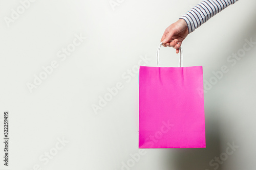 Female hand holds a shopping bag on a white background. Concept shopping, discount, sale. Banner